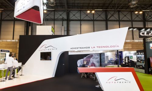 Glass meeting room within automotive exhibition stand featuring sleek materials and modern lighting