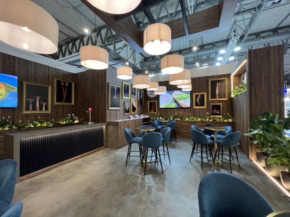 Custom exhibition stand built for Seafood Expo Global in Barcelona, featuring a hospitality area with wood finishes, suspended lighting and meeting tables.